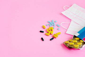 medical masks and tablets on a pink background
