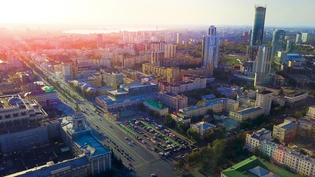 Modern city with canal on background of setting sun. Stock footage. Top view of beautiful panorama of modern city with canal in summer sun
