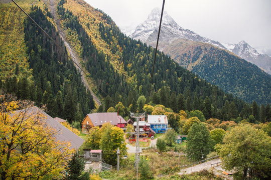 Dombay ski resort from the cableway chairelift, beautiful mountains landscape, small village and large snowy peaks in autumn, shues of traveler, Caucasus, Russia