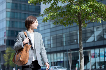 ビジネス街に佇むスーツを着た若いビジネスウーマン