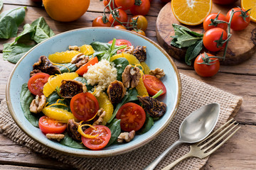 Colorful summer sweet salad with spinach, orange, cherry tomatoes, walnut, figs, quinoa, fresh fruit
