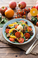 Colorful summer sweet salad with spinach, orange, cherry tomatoes, walnut, figs, quinoa, fresh fruit