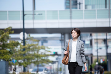 ビジネス街に佇むスーツを着た若いビジネスウーマン