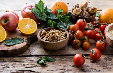 Colorful summer sweet salad with spinach, orange, cherry tomatoes, walnut, figs, quinoa, fresh fruit