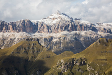Green hills and snowy rocks of Sella mountain group. View from Marmolada, Dolomites, Italy
