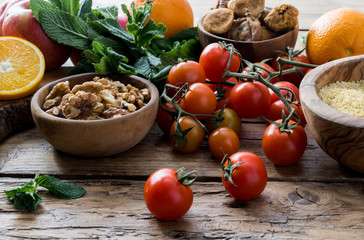 Colorful summer sweet salad with spinach, orange, cherry tomatoes, walnut, figs, quinoa, fresh fruit