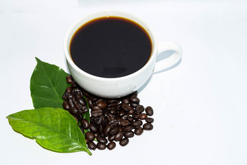 Roasted coffee beans with a white coffee mug