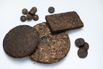 Pressed pancakes and bricks of puer tea of different kinds. Dry Chinese tea of high quality. White tea in pressed pancake on a white background. Tasty and healthy drinks for health.