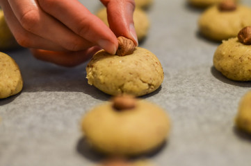 decorating cookies with an hazelnut before baking close up