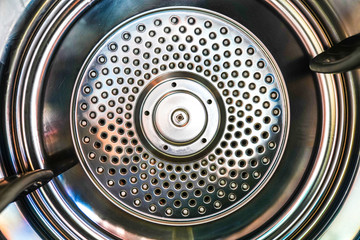 Washing machine drum interior. Perforated stainless steel drum for automatic washing machine.