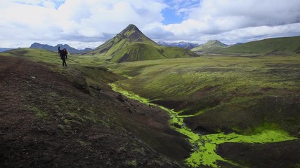 A young girl on a beautiful green mountain on the 54 km trek from Landmannalaugar, Iceland