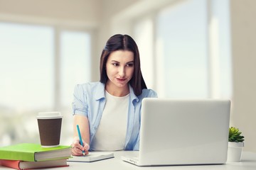 Young woman sitting at the desk with laptop