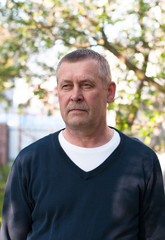 Portrait of handsome middle aged european man with mustache on backyard background in sunny spring day