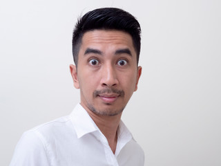 Obraz premium Shocked face of Asian man in white shirt on white background.