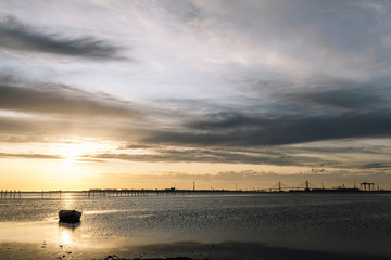 Obraz premium traditional wooden boat at sunset in the bay