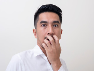 Shocked face of Asian man in white shirt on white background.