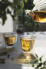 Summer linden flowers tea with splashes on white light table with bokeh