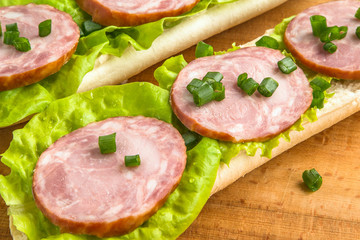 sandwich with fresh cabbage and onion sausage and cheese. hearty food.