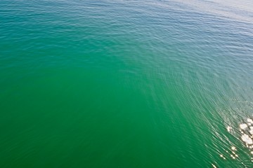 Obraz premium green sea surface with glare of the sun