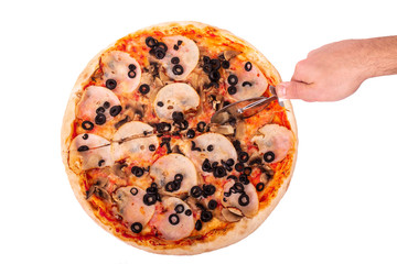 The man cuts the italian pizza with ham, mozzarella, mushrooms and olives, with a pizza cutter. Top view, isolated on white background