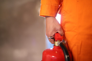 Focus on the fire extinguisher, the man carried the fire extinguisher to put out the fire in the building.