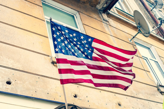 USA flag waving on old house background, vintage style