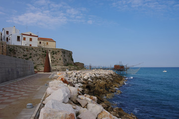 In the foreground the cliff and in the background the ancient village of Termoli and a fishing...