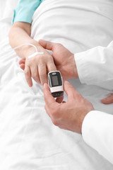 Male doctor working with elderly patient in hospital room