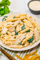 Chicken Alfredo with Spinach on Wooden Background. Selective focus.