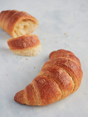 horn shape whole croissant close up view and another split in the background out of focus