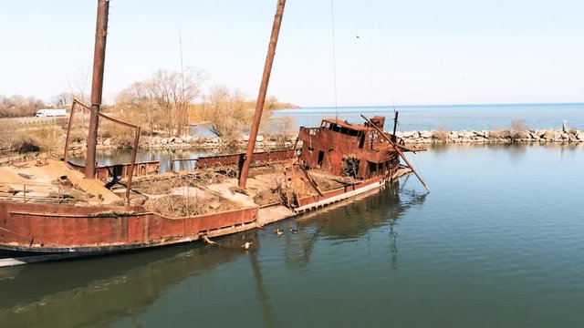 Drone view of geese playing on a rusty shipwreck