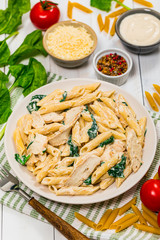Chicken Alfredo with Spinach on Wooden Background. Selective focus.