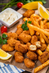 Crispy Fish Bites Snack Size. Deep Fried Pollock Fish Fingers and French Fried Potatoes with Tartar Dipping Sauce. Selective focus.