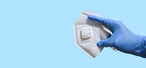 Hand in rubber glove with n95 mask. KN95 or N95 mask for protection pm 2.5/pm2.5 and corona virus (COVID-19).Anti pollution mask.air face mask on blue background with copy space.
