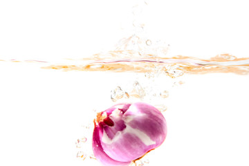 fresh onion falling into clear water splash and ripple isolated on white background