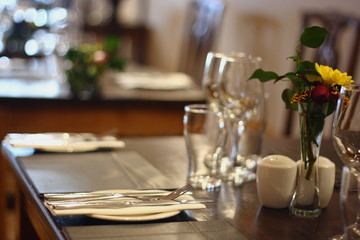 close up shot of a restaurant table set up with tableware and wine glasses. Concept of dining, hospitality and catering. Horizontal image with free space for text