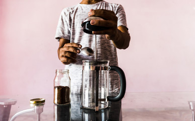 Man making coffee with French press coffee maker at home in lockdown 