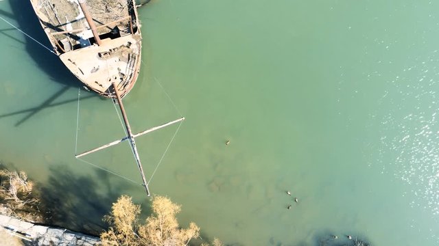 Flyover drone view of a rusted shipwrecked boat