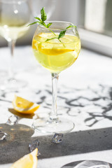 A Margarita Cocktail with a lemon slice in the glass. Lemonade or mojito cocktail with lemon and mint, cold refreshing drink or beverage with ice. Homemade limoncello in a glass