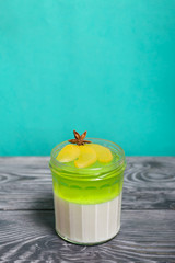 Cream jelly in white and green. Garnished with peach slices and anise star.