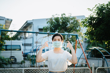Demonstration to wearing a surgical mask at outdoor, Asian woman protect  the virus Covid-19 pandemic, stay safety and social distancing concept for protect from Corona virus