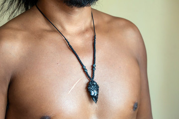 Male chest wearing elegant necklace with natural mineral gemstone