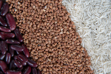 Raw rice, buckwheat and beans are laid out in strips as a backdrop.