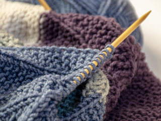 Close up wool colored knitting gold needle, kniting woolen texture, grey ball of woolen yarn