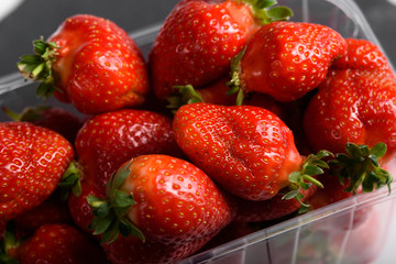 Fresh organic strawberries isolated on a black background. Delivery of natural products. Packaging made from organic strawberries.