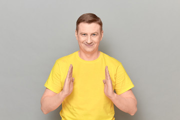Portrait of happy mature man showing size of something