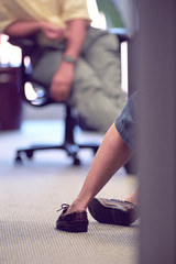 Legs of office mate sitting with colleague at office