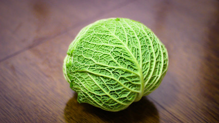 Fototapeta premium the head of green cabbage stands on a table