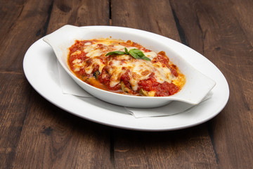 Tasty lasagna with meat covered with cheese served on white plate. Italian cuisine.