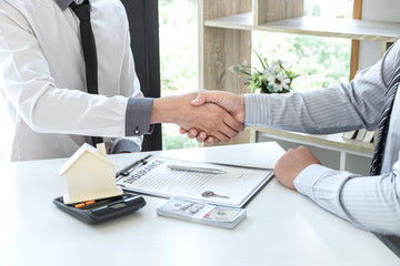 Fototapeta premium Real estate agent are shaking hands after good deal and giving house, keys to customer after signing contract to buy house with approved property application form